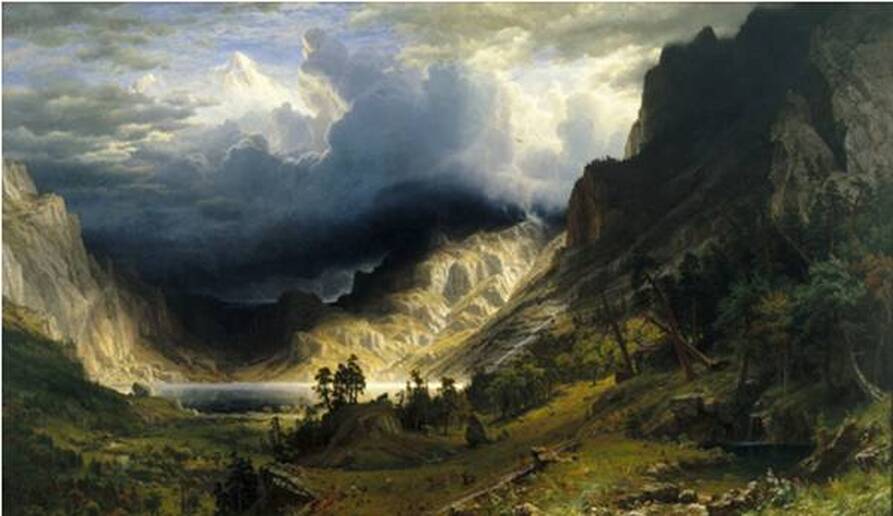 A mountain valley with dramatic clouds overhead